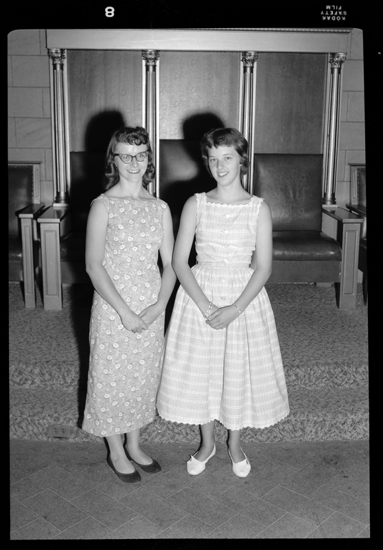 Peggy Foster (left) and Cathie Russom (right) stand together while posing for a picture. They are both dressed nicely and smiling.
