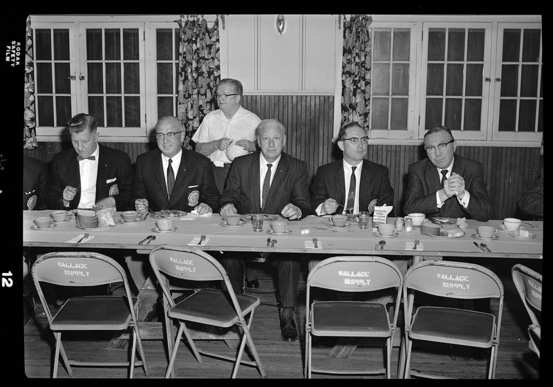 Photo of five men seated at a table at an event for the Gyro District Governor.