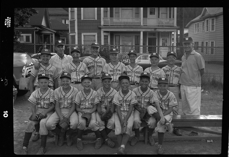 Group photo of the little league all-star baseball team and their coaches. Most of the children are wearing matching baseball uniforms with "Goodman's Royal Tire" on the front.