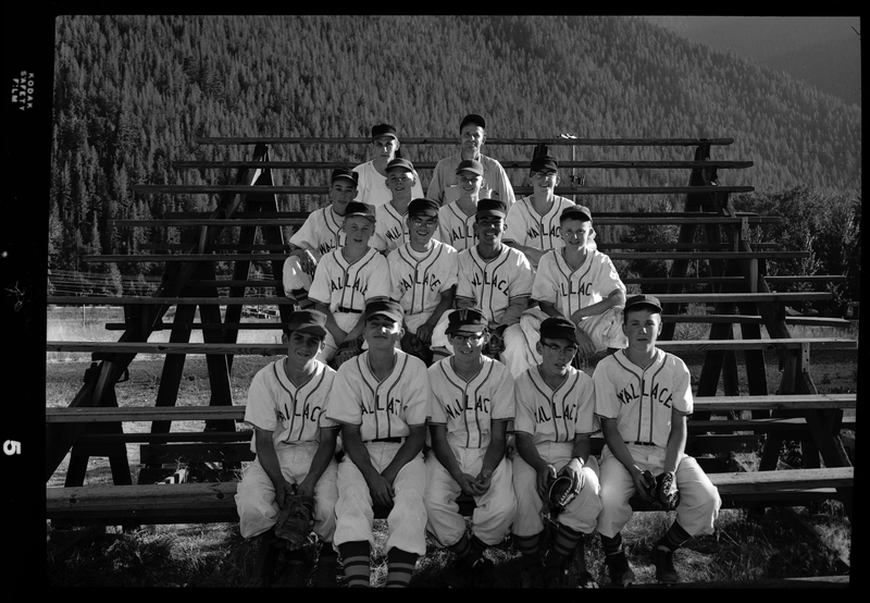 Group photo of the Babe Ruth all-star baseball team members sitting together on a set of bleachers. They are wearing matching uniforms and some have their gloves on.