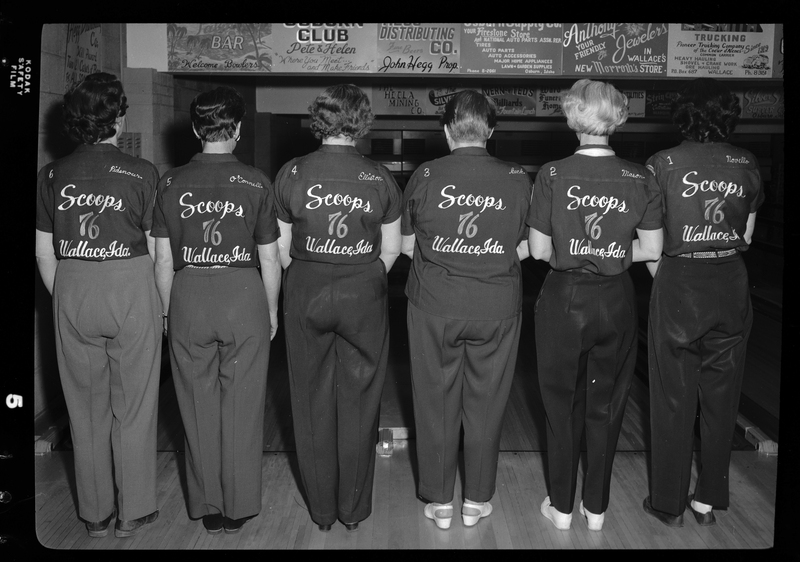 Photo of the Scoops bowling team facing away from the camera to show the back of the six women's shirts.