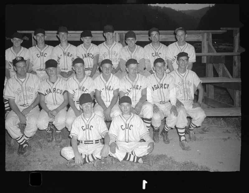 Photo of the Babe Ruth all-star baseball team posing for a photo on a set of bleachers. Front row: (unknown), (unknown). Middle row, from left to right: Manager Leonard Olson, Mike Keller, (unknown), Gary Fernquist, Loren Solum, LeRoy Viche & Meredith Stone. Back row, from left to right: Jim Thompson, Richard Sands, (unknown), (unknown), Bob Gust, Tiny Yost, (unknown) & Coach George Vipperman. The members of the team are wearing uniforms with various acronyms: "C.U.C." team was for Wallace's Citizens Utility Company. "ASARCO" was the name of a mining company. "Osburn Lions" was the Lions Club service organization in Osburn, ID. The "CDA H&F Co"  was the Coeur d'Alene Hardware & Foundry Company of Wallace, ID.