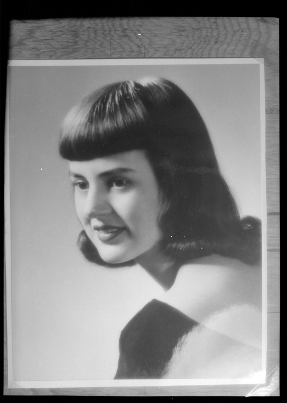 Photo of a portrait of Cleo Bardelli, who was crowned the Queen of Wallace, Idaho's Silver Jubilee. She is looking over her shoulder. This photo was used in the promotion of the city's 75th Jubilee celebration during the summer of 1958. Cleo was the daughter of Guido & Mary Bardelli of Osburn, ID.  Guido, also known as 'Young Firpo' and the 'Wild Bull of Burke', who was a famed Pacific Northwest championship boxer from Burke, Idaho, in the 1920's and 1930's.  Guido 'Firpo' Bardelli was inducted into the World Boxing Hall of Fame in 2008.