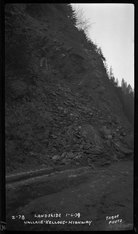 Landslide on the Wallace-Kellogg highway, as written on the photo. Only the landslide is visible in this photo. Previously described as "Rock slide, Rocky Point, 1 mile west of Wallace, Idaho."
