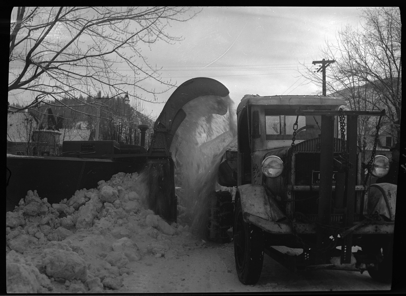 Photo of a snow loading truck that is actively moving snow from the street.