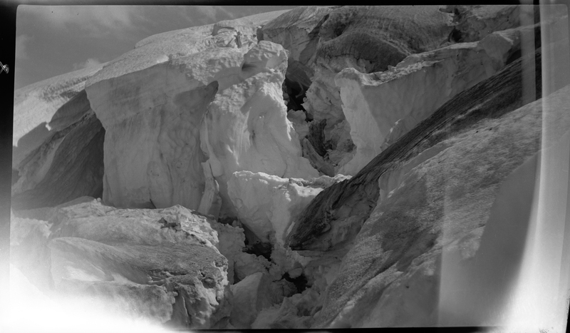 Photo of a snow pile that is split at Jack Waite Mine. Part of the negative is damaged.