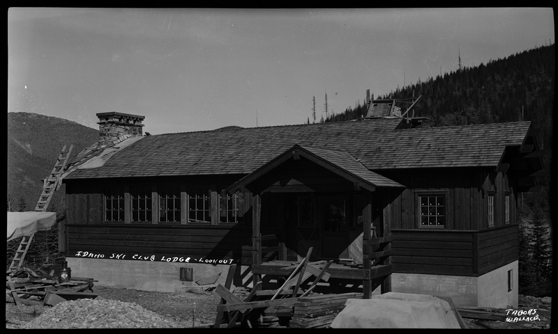 Photo of the Idaho Ski Club Lodge at Lookout Pass. There is a ladder leaning against the roof of the building and it appears that there is ongoing construction happening to the building.