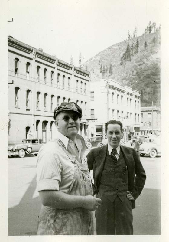 George Tabor (right) and an unidentified man look at the camera while standing in front of a street.