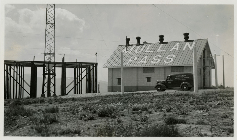 A J.W. Tabor car parked outside the Lookout Pass radio beam station. "Mullan Pass' is painted on the side of the roof.