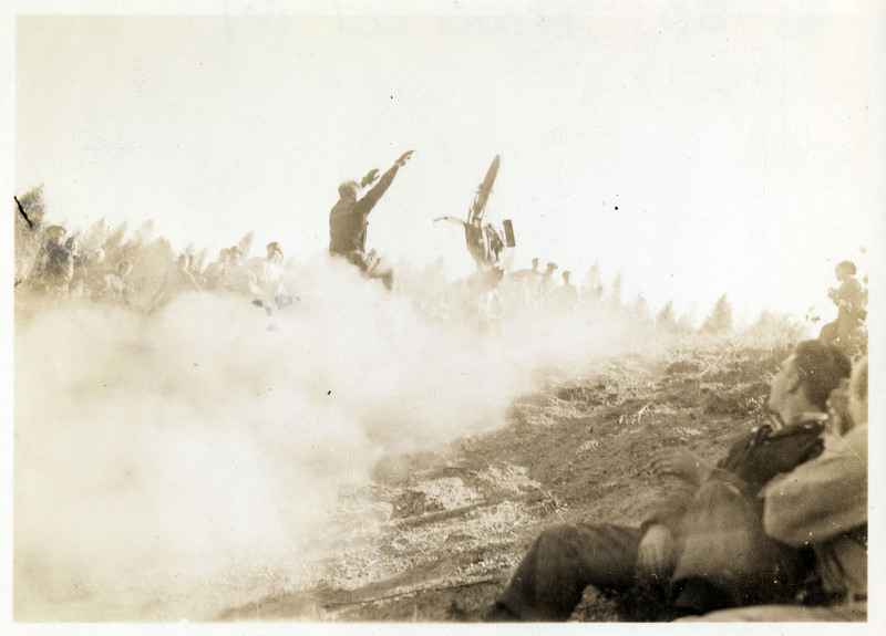 A man falls off a dirtbike at the Idaho Hill Climb in Osburn, Idaho. A crowd of people watch the man through the dust.