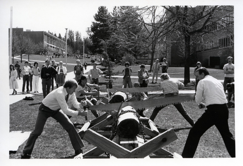 A photo of Dean John Ehrenreich with students and faculty in the log sawing competition. 
