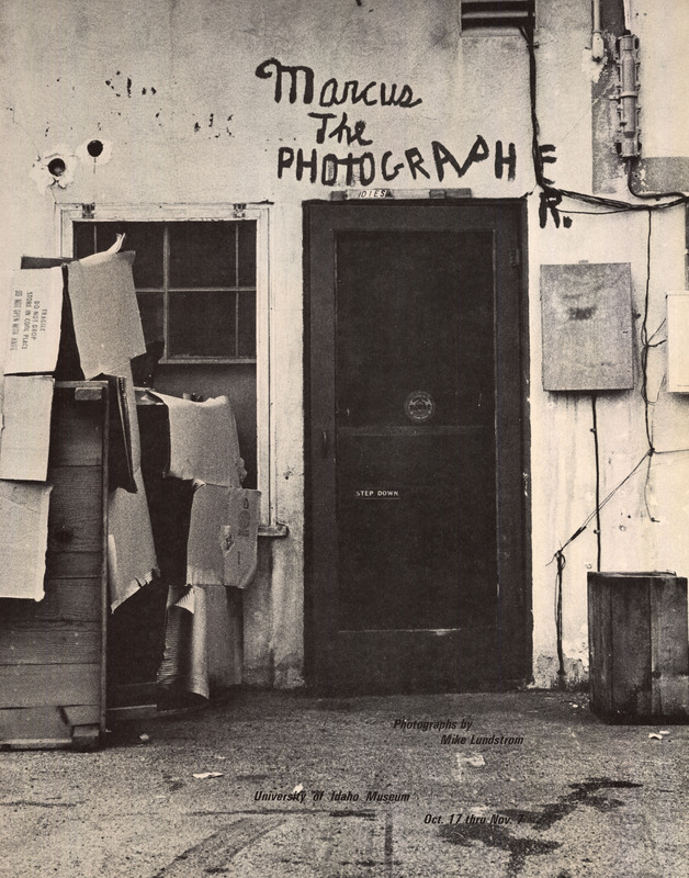 Poster advertising a photography exhibition by Mike Lundstrom. The text is overlaid over one of Lundstrom's photographs depicting the side of a building with a door, window, and boxes.