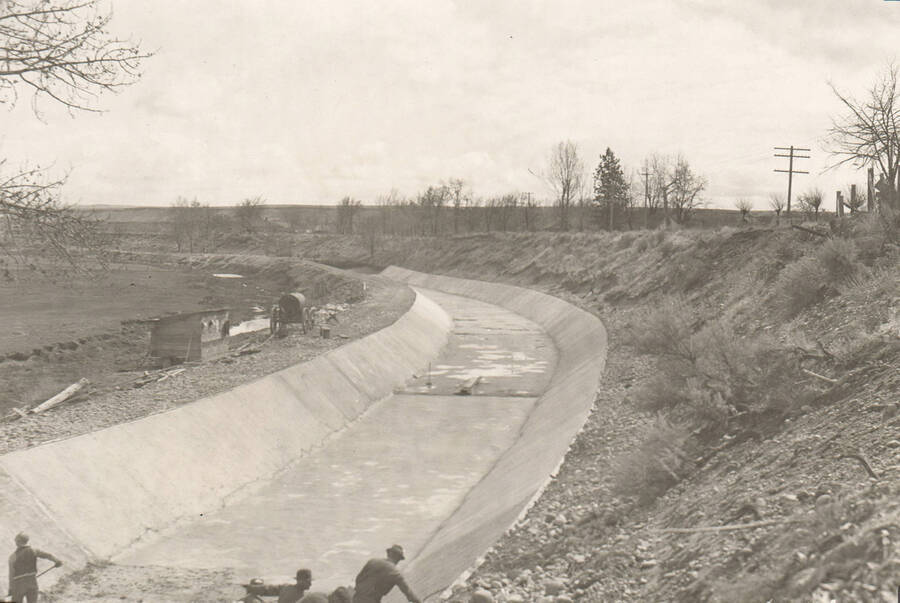 A nearly complete irrigation canal. Men work in foreground. Note: This image is part of a Work Progress Administration publicity series.