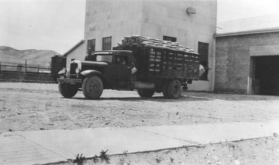 Photo text: 'Commercial truck loaded with fifteen thousand pounds of poisoned bait in fifty pound bags.' This image is part of a report by the United States Department of Agriculture Biological Survey on predation and pests.