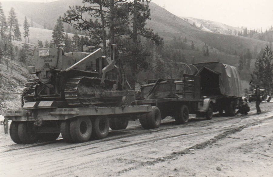 Photo text: 'Moving the bulldozer, Trucks and 'dozer  belong to CCC-ID, trailer to Idaho Dept. of Public Works.' Note: This image is part of a narrative pictoral report to accompany quarterly enrollee program report.