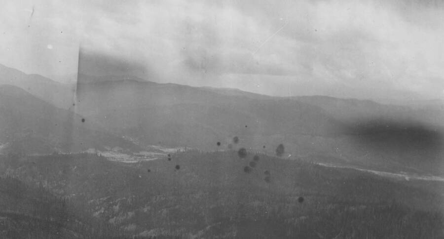 Photo text: 'Showing tailings of placer mines and denuded slopes. Restocking burns in foreground.' This is image is part of a report on the proposed Payette Forest Reserve by R.E. Benedict, 1904.
