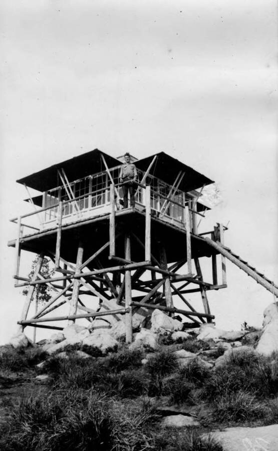 A man stands on the deck of an unknown fire lookout (possibly the Missouri Ridge Lookout).