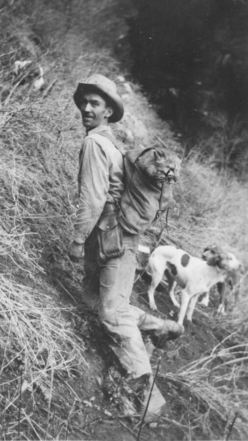 Photo text: 'Frank Buck isn't the only one that 'Brings 'em Back Alive'. Roy Tumelson with cougar kitten taken on Crooked River, Salmon River Drainage, Winter 1935.' This image is part of a report by the United States Department of Agriculture Biological Survey on predation and pests.