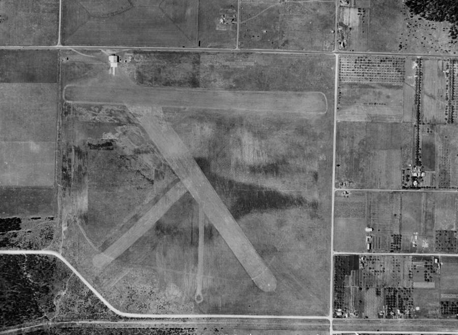 Aerial image of Weeks Field, the first airfield in Coeur d'Alene and, by some sources, the first municipally owned airport in the United States. Closed in the 1940's or 50's it was located on the site of the current Kootenai County Fairgrounds. Farms and residential areas can be seen to the north of the field.