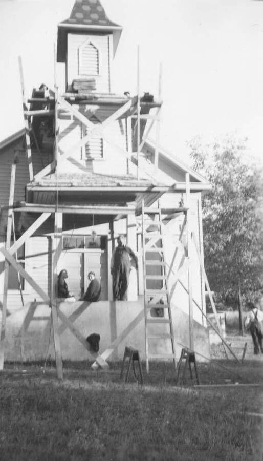 Photo caption: 'The East Kamiah Church is repaired by Indian workmen.' This image is part of a report regarding farm organizations among tribes in Northern Idaho and the CCC-Indian Division.