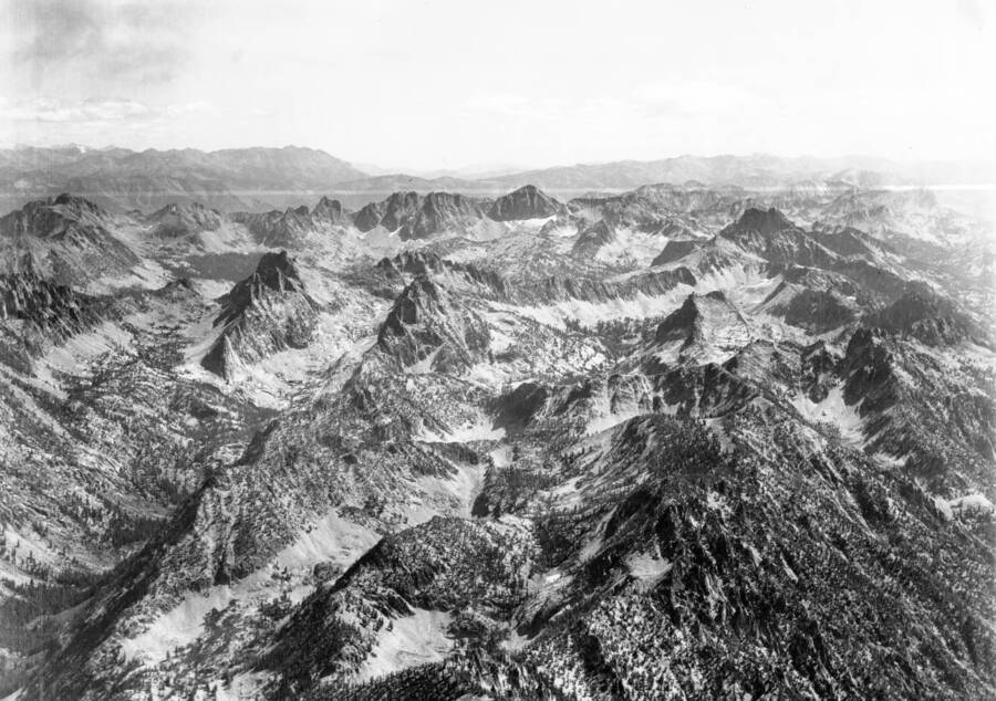 Photo caption: 'The ridge to the immediate foreground is the divide between Goat Creek and the South Fork of the Payette River. The well defined dark peak in the upper center is Mount Cramer. Other peaks showing are Elk Peak, Reward Peak, Packrat Peak, Red Fish Peak, Coney Peak. Main drainage on the left is Goat Creek. All the drainage this side of Packrat Peak and Elk Peak and left of Cony Peak flows into Goat Creek. The drainage heading just right of Coney Peak is Garden Creek. Directly behind Packrat Peak and left of Elk Peak is the head of Red Fish Creek.
