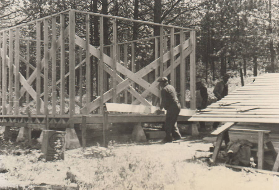 Photo text: 'Nez Perce Reservation. Forest Guard Cabin being constructed on the Cold Springs Reserve. Assistant Leader James Miles in foreground.' Note: This image is part of a narrative pictoral report to accompany quarterly enrollee program report.