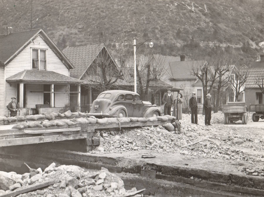 Photo text: 'Flood damage in Wallace, Idaho April 1938, caused by Placer Creek. The watershed of Placer Creek was burned by forest fires in 1910. Since that time Wallace has been menaced by periodic spring freshnets, caused by the rapid melting of deep snow on denuded slopes.'