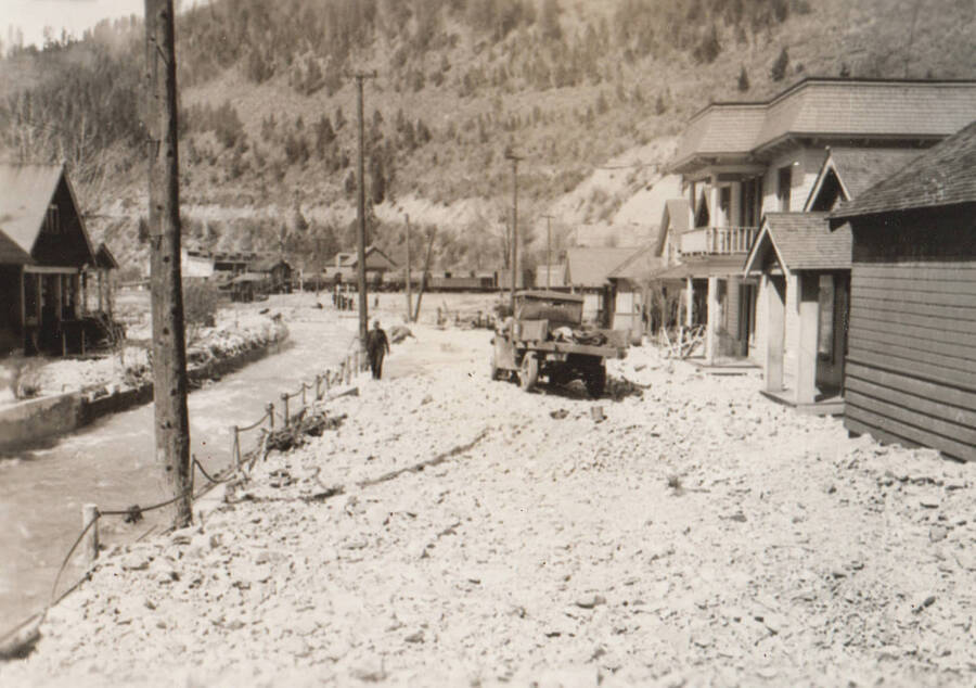 Photo text: 'Emergency flood work, Wallace. Four feet of gravel and rock left on principal street by Placer Creek (left).' Note: This image is part of a Work Progress Administration publicity series.