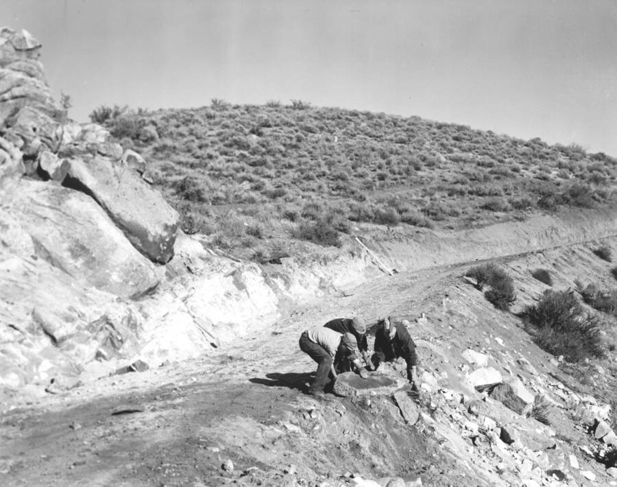 CCC workers from Mountain Home Camp G-99 remove large rock debris from road. Image part of CCC-Idaho Indian Division.