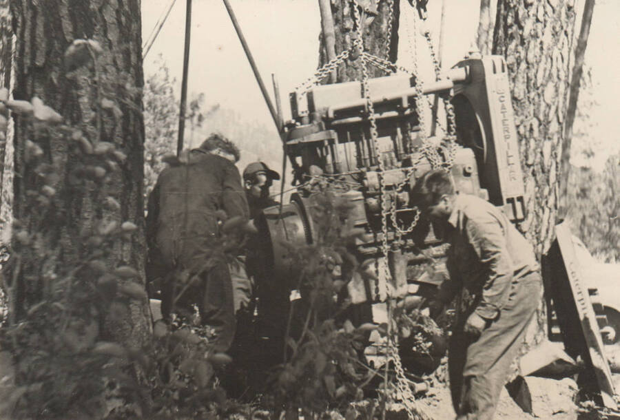 Three men work to repair a bulldozer. Note: This image is part of a narrative pictoral report to accompany quarterly enrollee program report.
