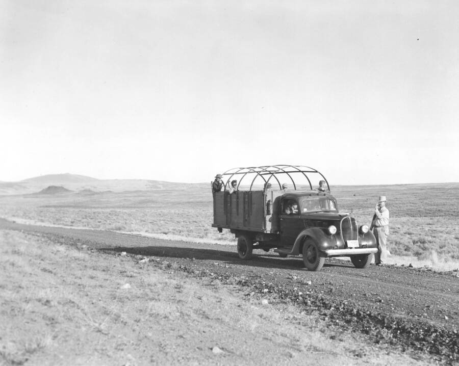 A man waives to a CCC workers from Mountain Home Camp G-99 in transport truck. Image part of CCC-Idaho Indian Division.