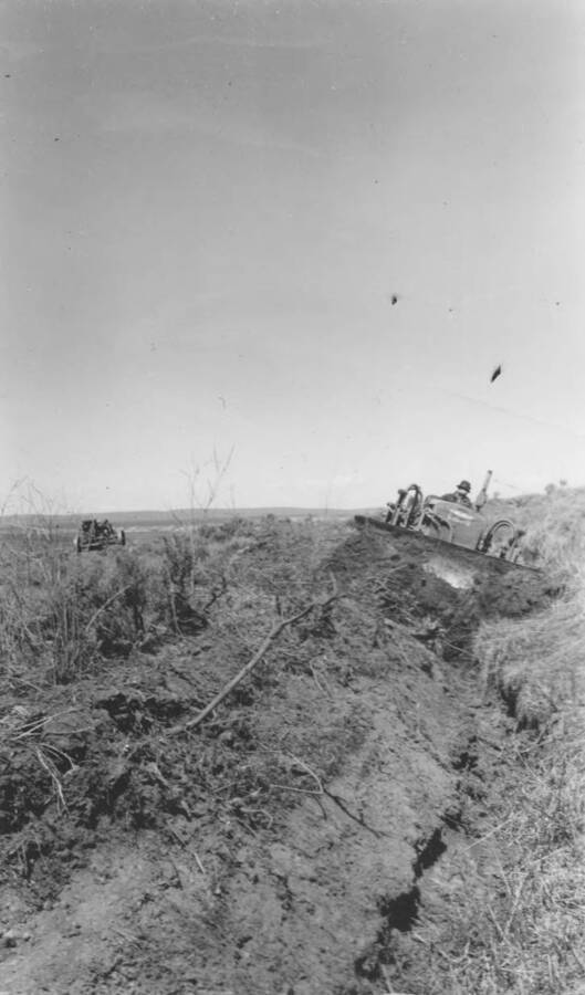 A man digs a ditch with a tractor. Note: This image is part of a report by V.W. Balderson to Director of Indian Affairs, D.E. Murphy on CCC-Indian Division Projects completed by the Fort Hall Agency, Fort Hall, Idaho.