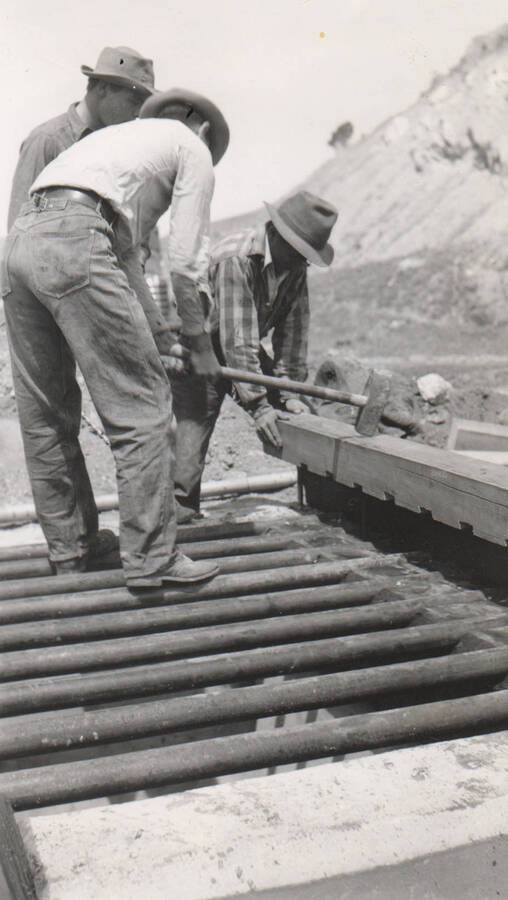Men use sledge to assemble finishing parts of a cattle guard on Arbon Trail. Note: This image is part of a report by V.W. Balderson to Director of Indian Affairs, D.E. Murphy on CCC-Indian Division Projects completed by the Fort Hall Agency, Fort Hall, Idaho.