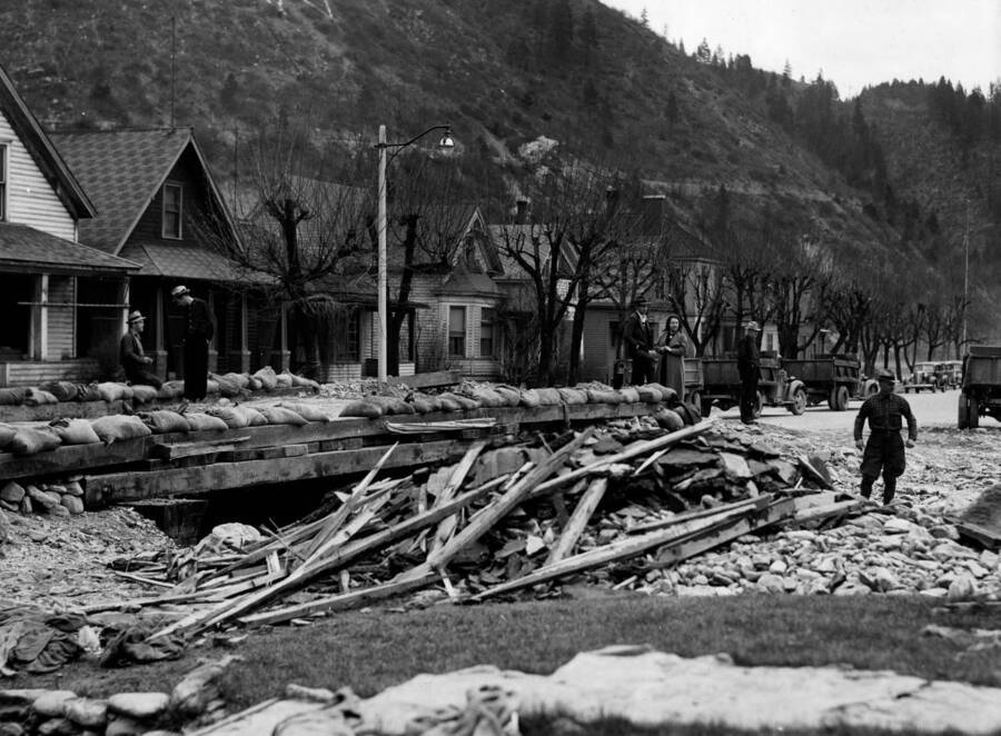 Photo text: 'Flood damage in Wallace, Idaho April 1938, caused by Placer Creek. The watershed of Placer Creek was burned by forest fires in 1910. Since that time Wallace has been menaced by periodic spring freshnets, caused by the rapid melting of deep snow on denuded slopes.'