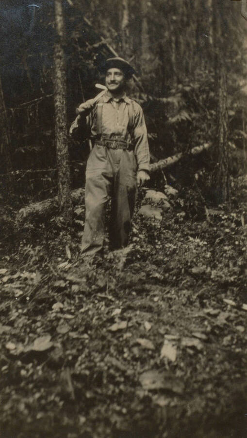 Photo text: 'The author at work clearing timber at the Priest River Experiment Station site.' This image is part of a pictorial narrative by William W. Morris titled 'Experiences on a National Forest'.