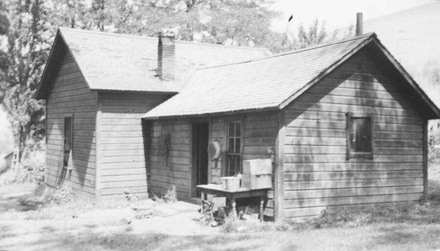 Photo caption: 'Conley Seth wanted his house repaired, raised, leveled, and a new floor. Rear view.' This image is part of a report regarding farm organizations among tribes in Northern Idaho and the CCC-Indian Division.