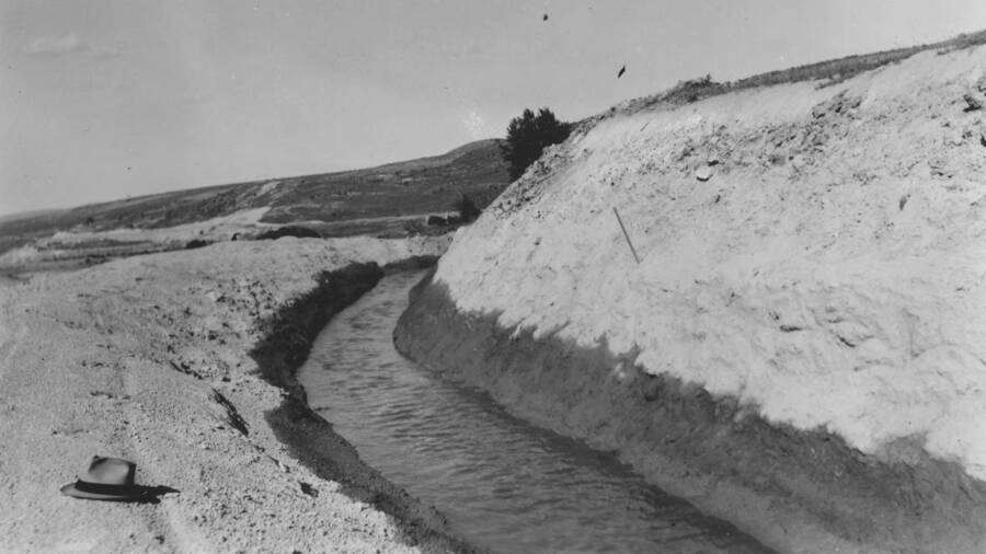 Hat sits near Little Indian Ditch project. 'Project 139, Rehabilitation of Community Irrigation System, $1520. Under authority dated February 1, 1940, $200 was added to project. Work has been accomplished on Little Indian and Ollie Farmer ditches. Difficult work experienced on Little Indian Ditch.' Note: This image is part of a report by V.W. Balderson to Director of Indian Affairs, D.E. Murphy on CCC-Indian Division Projects completed by the Fort Hall Agency, Fort Hall, Idaho.