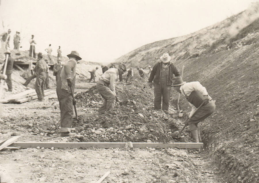 Men reline a irrigation canal. Note: This image is part of a Work Progress Administration publicity series.