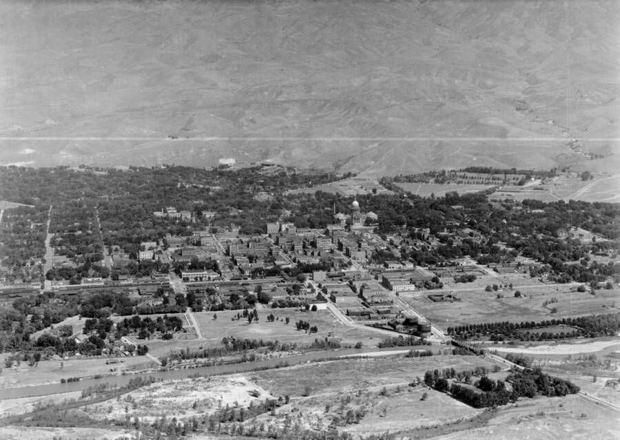 Photo text: 'Boise River in the foreground and Boise Barracks in the distance. The town got its name from the French who saw the trees along the river in the distances they crossed the desert, cried 'Les Bois' - the woods. The town was called Boise City for a long time.' This image is part of a series of aerials taken by the Army Air Corps.