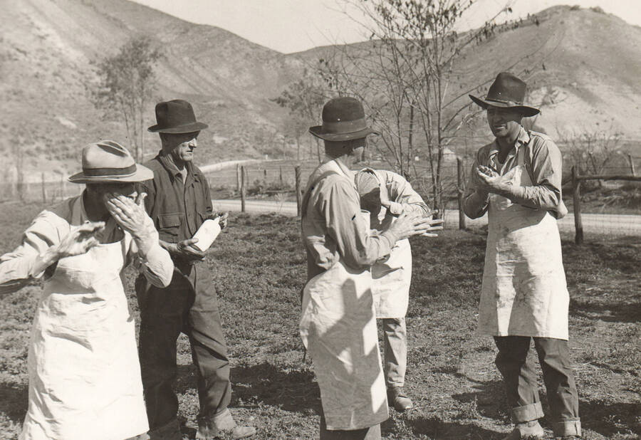 Men discuss Mormon Cricket control and insecticides. Note: This image is part of a Work Progress Administration publicity series.