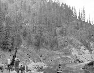 Photo text: 'The Lewis and Clark Highway, giving a view of the pioneer road under construction.' This image is part of a USFS series labelled 'American Guide'.