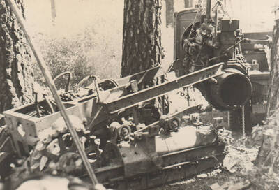 Bulldozer being 'torn down' for repair. The engine is being crane lifted in the upper right of the image. Note: This image is part of a narrative pictoral report to accompany quarterly enrollee program report.