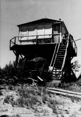Photo text: 'One to be destroyed as now abandoned. Under structure badly deteriorated. Ranger Val Simpson on steps.'