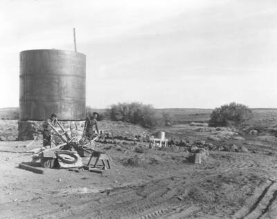 Two CCC workers from Mountain Home Camp G-99 pose with drawn plows and other equipment. Image part of CCC-Idaho Indian Division.
