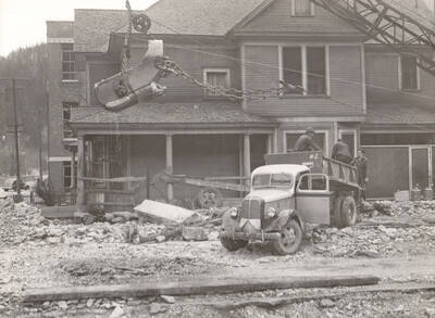 Photo text: 'Flood damage in Wallace, Idaho April 1938, caused by Placer Creek. The watershed of Placer Creek was burned by forest fires in 1910. Since that time Wallace has been menaced by periodic spring freshnets, caused by the rapid melting of deep snow on denuded slopes.'