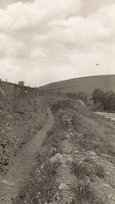 Photo text: 'Sanitarium Irrigation Project. Old irrigation ditch cleaned on a CCC-ID project.' Note: This image is part of a pictorial supplement to a report on the North Idaho Agency and the Civilian Conservation Corps - Indian Division by Sidney L. Johnston, Assoc. Forest Engineer.