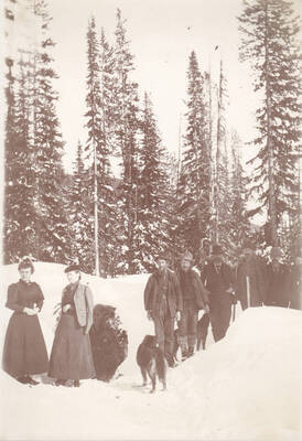 Men, women, and a dog travelling through the snow en route to Buffalo Hump.