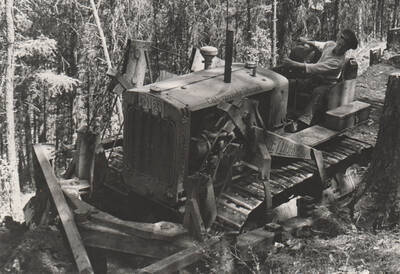 Photo text: 'Enrollee, Machine Operator, James Taylor 'dozing out the Tramway Reserve Truck Trail, Kamiah, Idaho. This reserve is on the Nez Perce Reservation.' Note: This image is part of a narrative pictoral report to accompany quarterly enrollee program report.