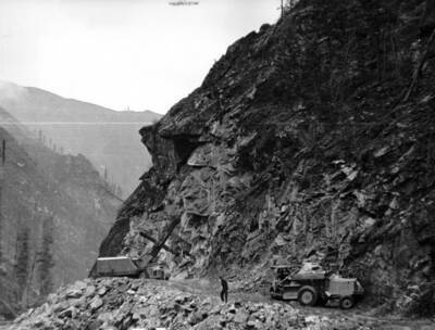 Photo text: 'The Lewis and Clark Highway Project. This was a six mile unit of a proposed road that would connect North Central Idaho with Missoula, Montana. It lies through a primitive area and as illustrated in the picture, a rocky one.' This image is part of a USFS series labelled 'American Guide'.