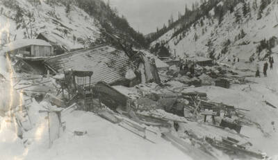 Photo text: 'Remains of houses and furniture were scattered everywhere.' This image is part of a pictorial narrative by William W. Morris titled 'Experiences on a National Forest'.
